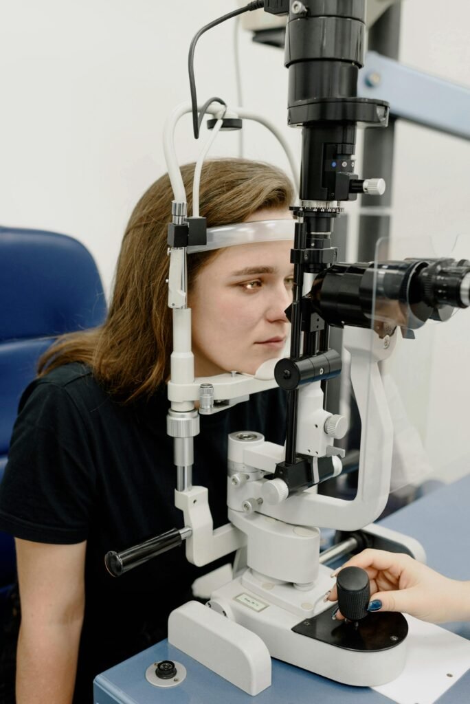 pexels-photo-5766073-5766073 A young woman receives an eye examination using modern ophthalmology equipment in a clinic setting.