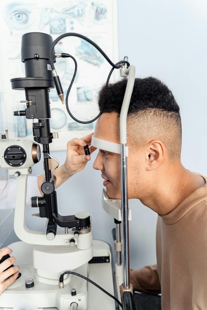 pexels-photo-6749699-6749699 A young man undergoes an eye examination using a slit lamp in a medical clinic.